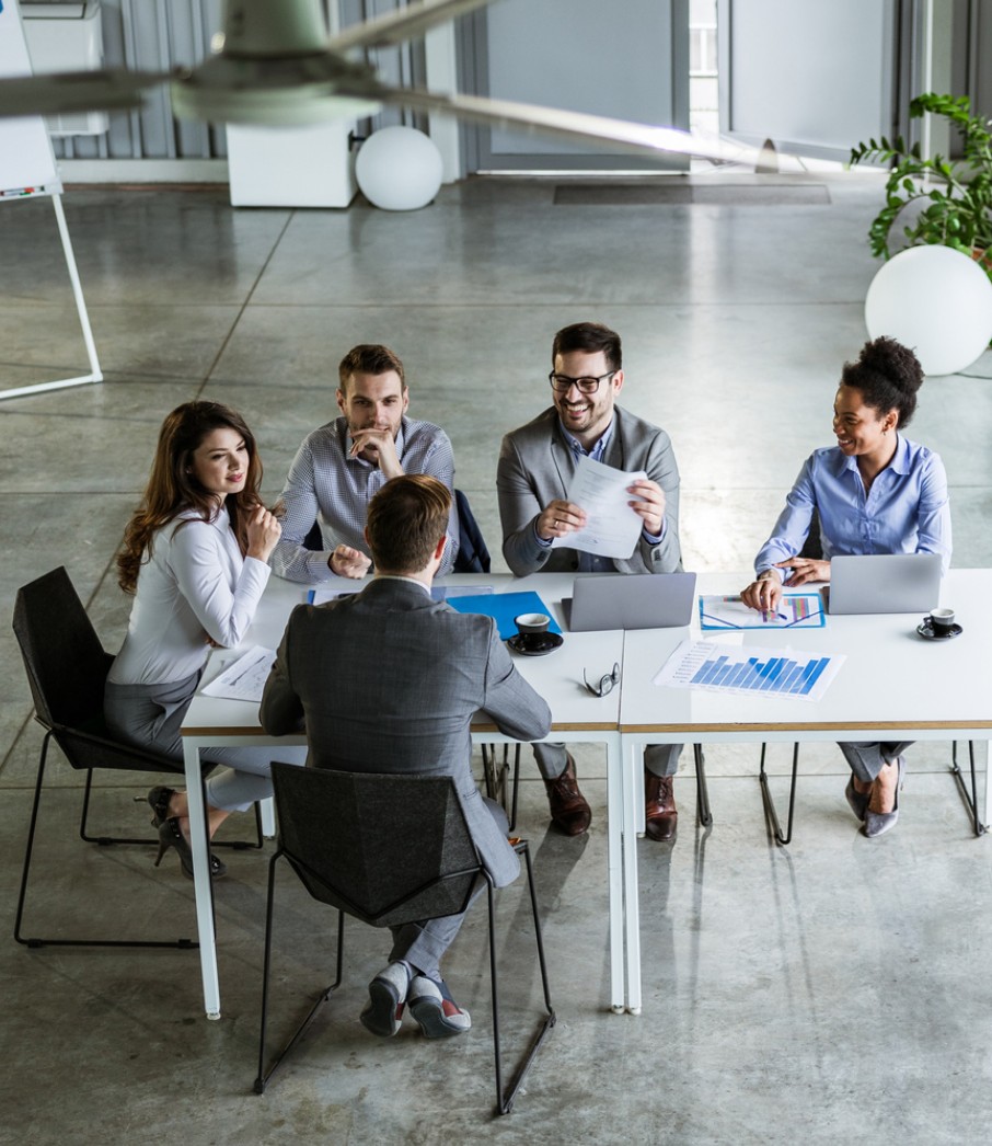 Various people at a table having a meeting.